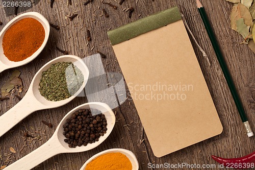 Image of Old notebook, spices in spoons