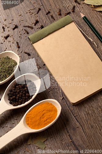 Image of Old notebook, spices in spoons