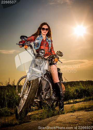 Image of Biker girl sitting on motorcycle