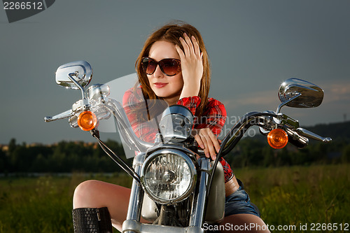 Image of Biker girl sitting on motorcycle