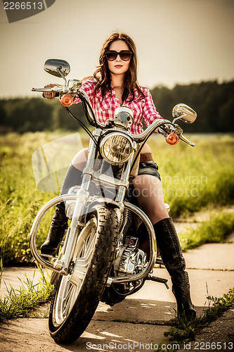 Image of Biker girl sitting on motorcycle