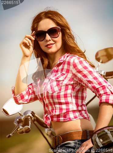 Image of Biker girl sitting on motorcycle