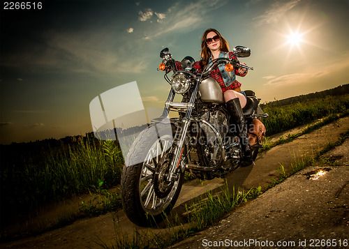 Image of Biker girl sitting on motorcycle