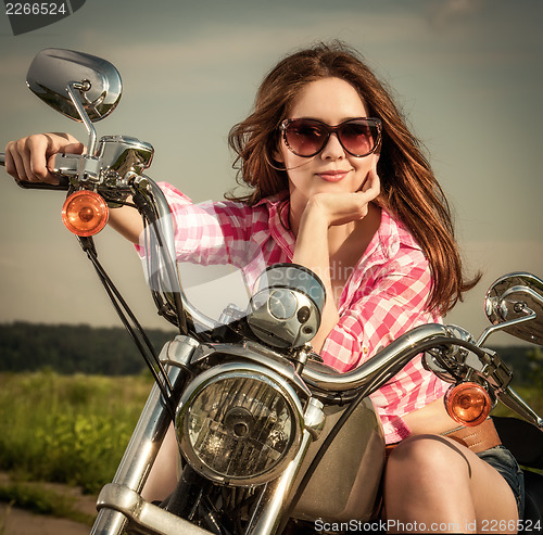 Image of Biker girl sitting on motorcycle