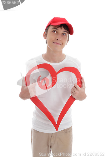 Image of Daydreaming boy holding red love heart