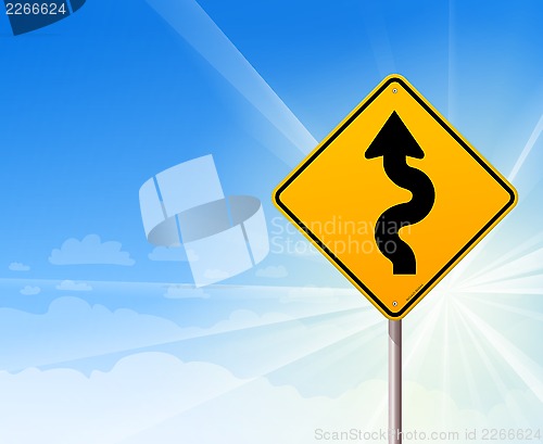 Image of Winding road sign on blue sky