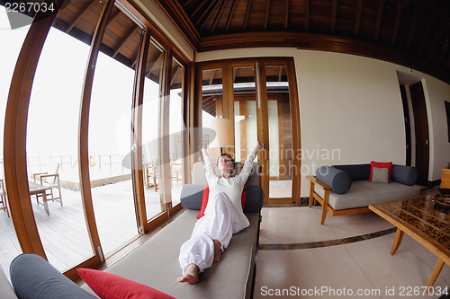 Image of happy young woman relax at home on sofa