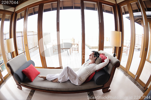 Image of happy young woman relax at home on sofa