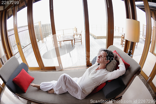 Image of happy young woman relax at home on sofa