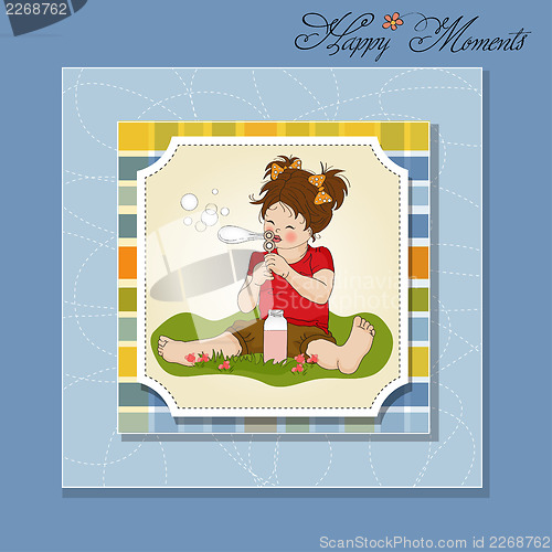 Image of funny lovely little girl blowing soap bubbles