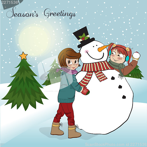 Image of two happy girls building a snowman