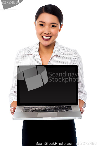 Image of Smiling saleswoman presenting brand new laptop