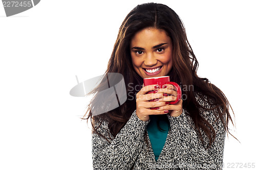 Image of Relaxed mixed race woman having coffee