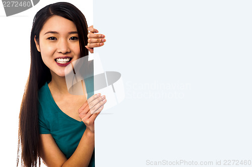 Image of Asian girl holding blank white ad board