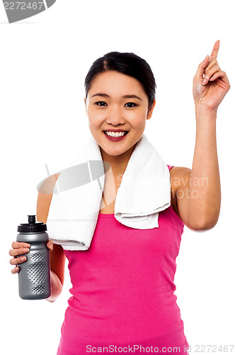 Image of Smiling fitness woman holding sipper bottle