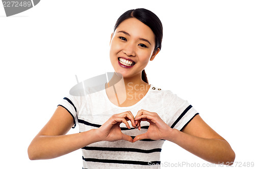 Image of Pretty woman making heart symbol with hands