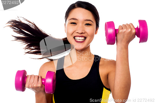 Image of Happy fitness woman lifting dumbbells