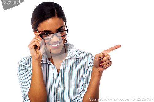 Image of Woman adjusting her spectacles and pointing away