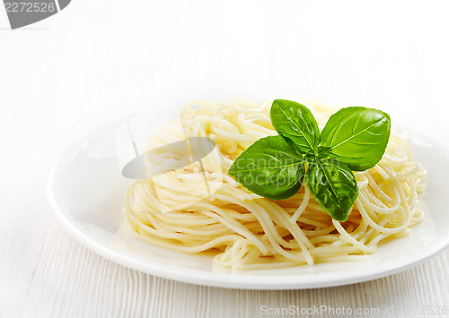 Image of Pasta spaghetti and green basil leaf on white plate