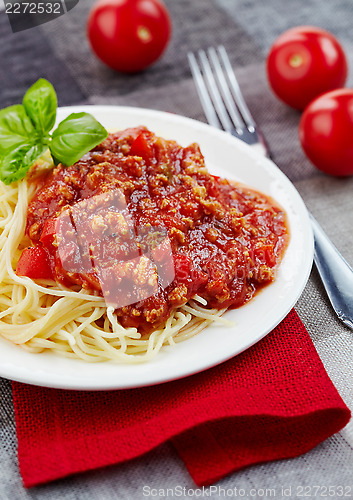 Image of Spaghetti bolognese and green basil leaf on white plate