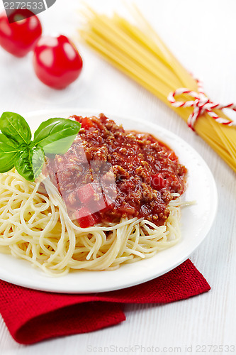 Image of Spaghetti bolognese and green basil leaf on white plate