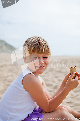 Image of Happy girl with ice cream on beach