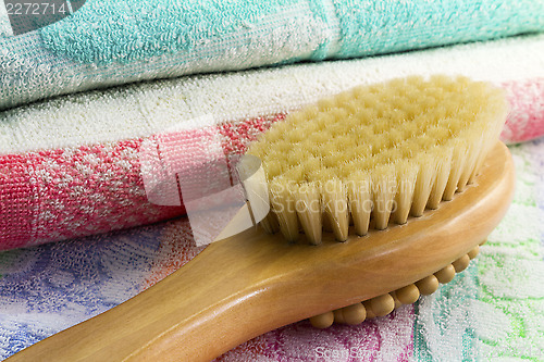 Image of Wooden brush with the handle for massage of a body and a towel. 