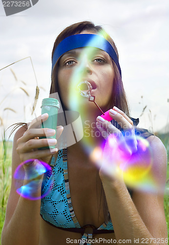 Image of woman blowing soap bubble