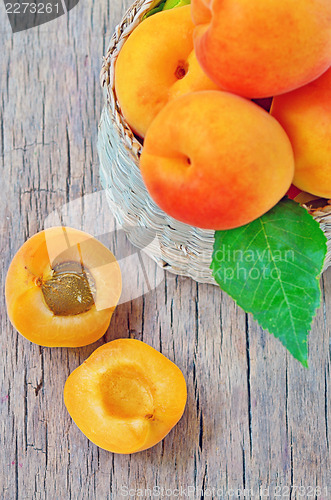 Image of fruits apricot in basket on wooden background