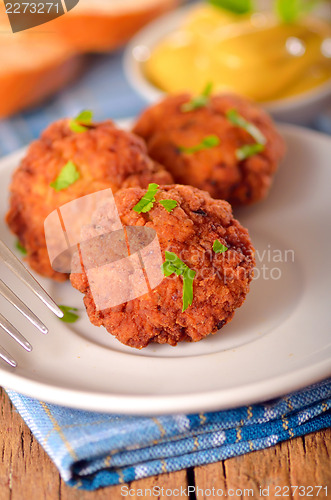 Image of meat balls with mustard on white dish 