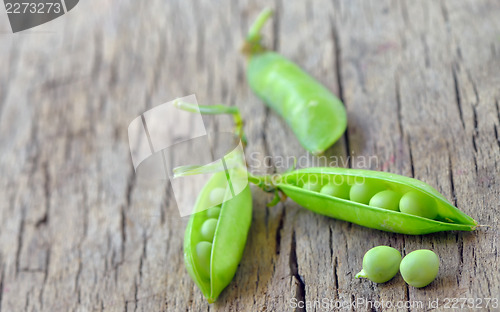 Image of Fresh green peas on an old wooden background