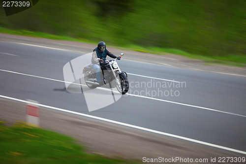 Image of Man traveling on a classic motorcycle - chopper