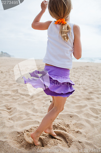 Image of Young girl playing on beach