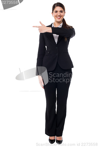 Image of Attractive corporate woman pointing away