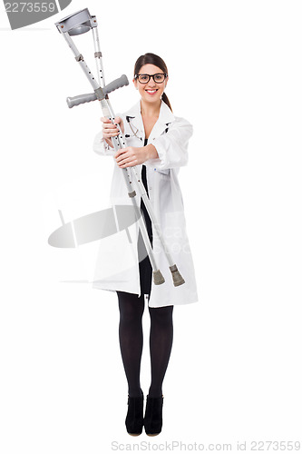 Image of Smiling medical expert holding pair of crutches