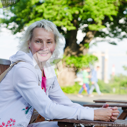 Image of Portrait of a woman relaxing at a table summer Cafe