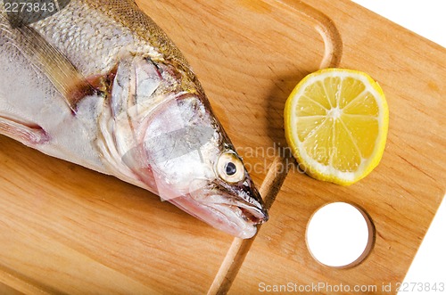 Image of Pike perch on a wooden kitchen board, it is isolated on white