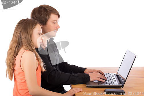 Image of Father working with his daughter on a laptop