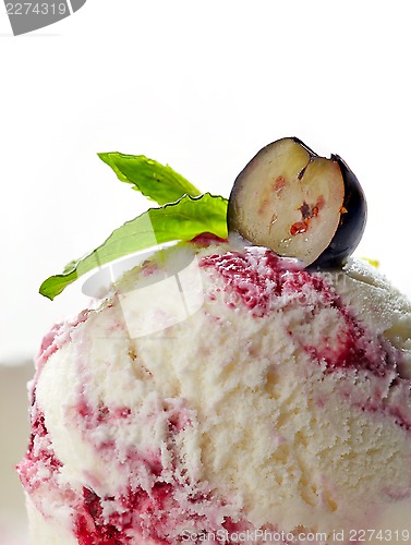 Image of closeup of blueberry ice cream decorated with mint and berry