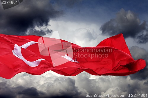 Image of Waving flag of Turkey against storm clouds