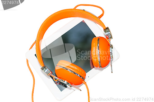 Image of White tablet computer with orange headphones isolated on white