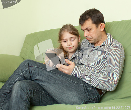 Image of Daughter  and father  using e-book