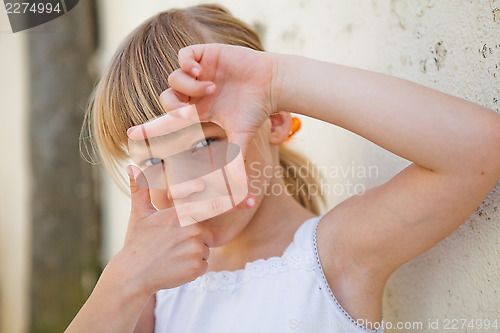 Image of Young girl doing picture frame sign