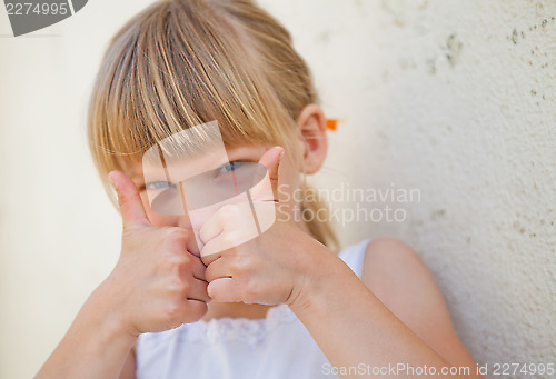 Image of Young girl doing ok sign