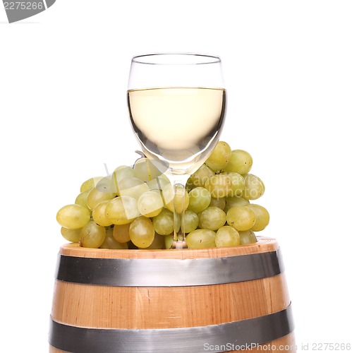 Image of barrel, glass of wine and ripe grapes on wooden
