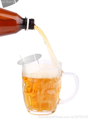 Image of Close up of bottle of beer pouring into a mug.