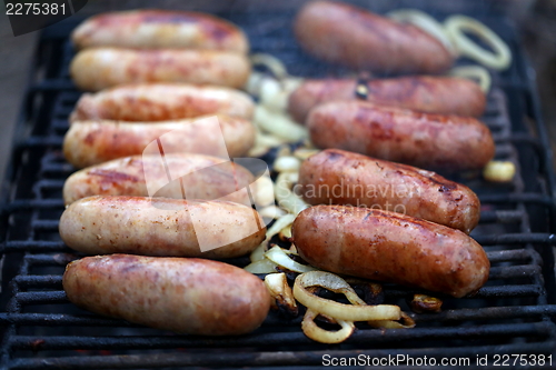 Image of A lot of bratwurst sausages on grill.