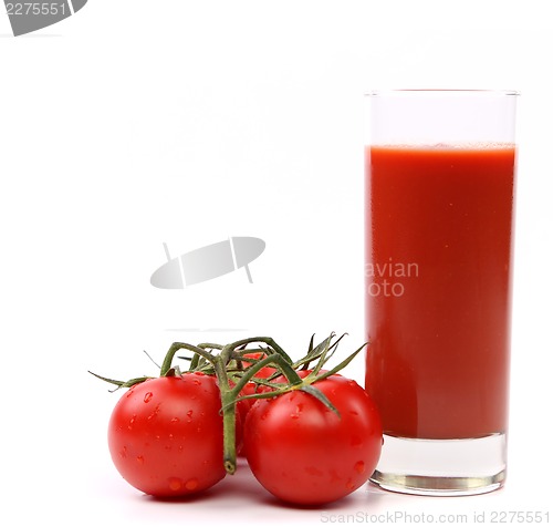 Image of Tomato juice in glass with a cluster of small tomatoes