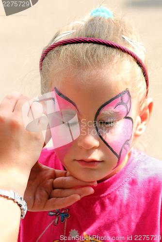 Image of artist paints on face of little girl