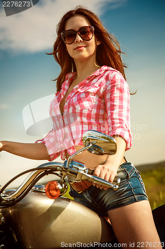 Image of Biker girl sitting on motorcycle